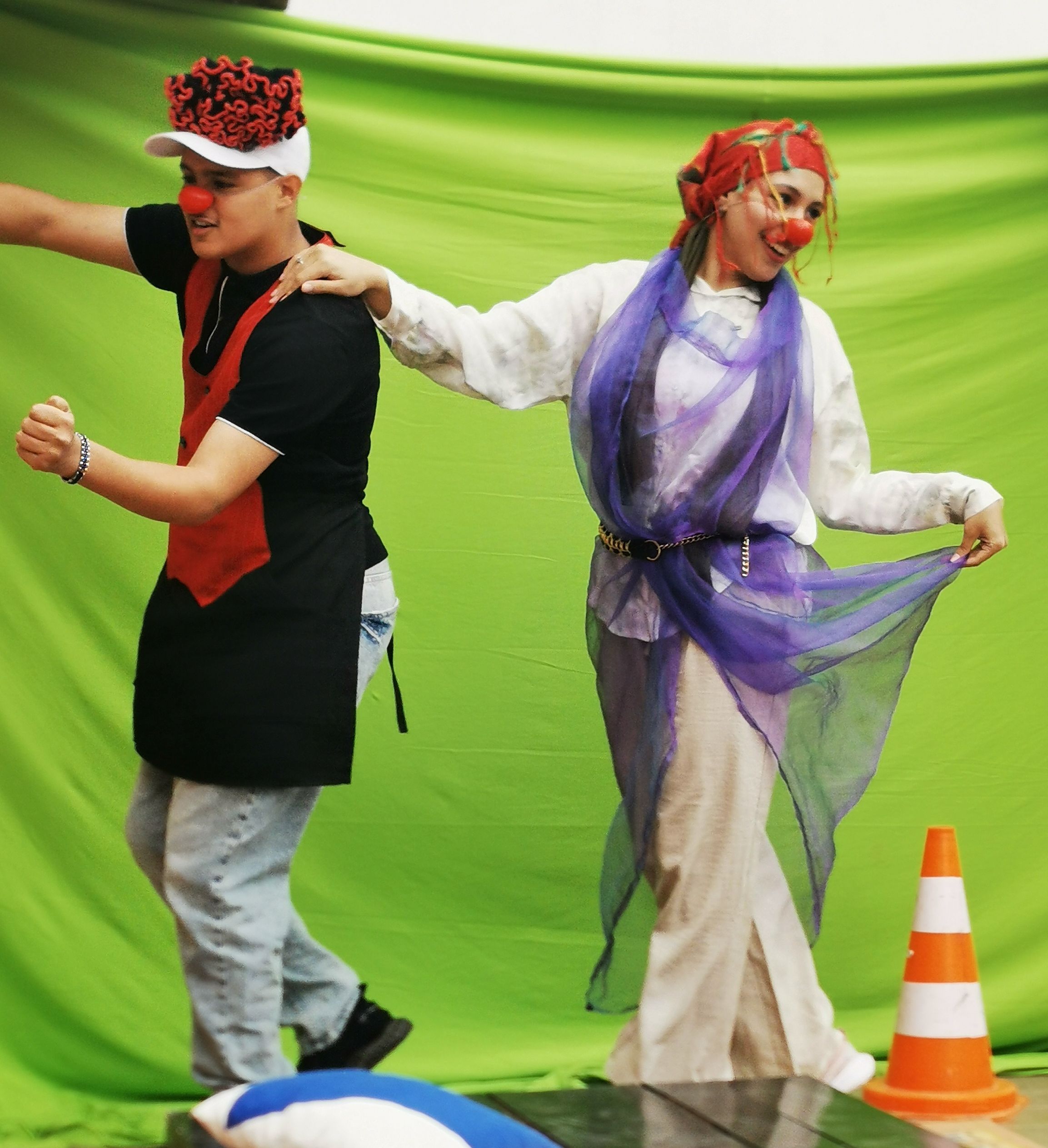Groupe de clowns costumés du spectacle La véritable histoire d'Aïcha devant un fond vert